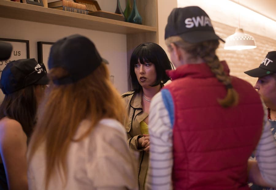 Unidad SWAT de compañeros interrogando a una sospechosa interpretada por una actriz profesional durante la misión