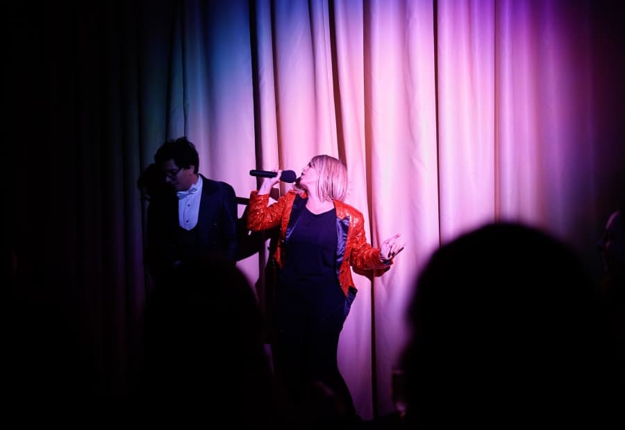Actress performing under stage lights during a live murder mystery show for companies in Barcelona