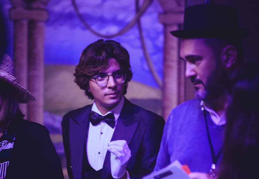 Actor in tuxedo handing a clue to participants during a team building murder mystery in Barcelona